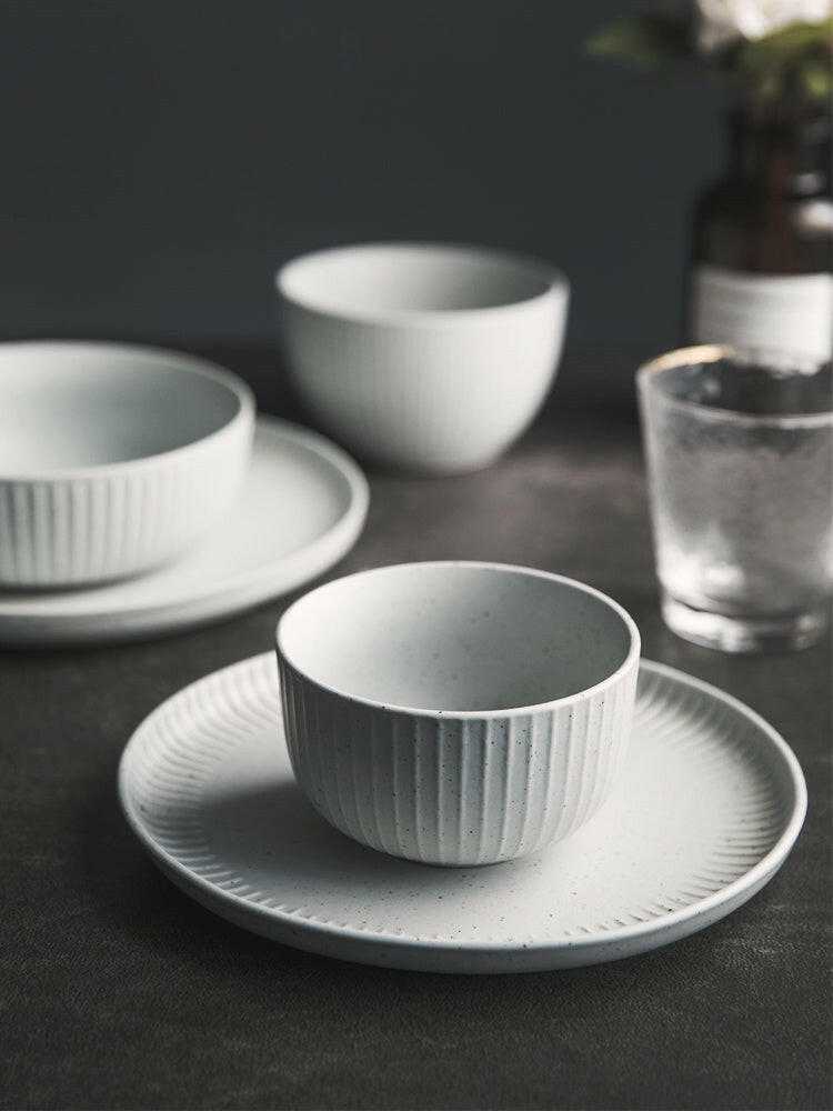 Stylized ceramic dinnerware set with matte finish.
