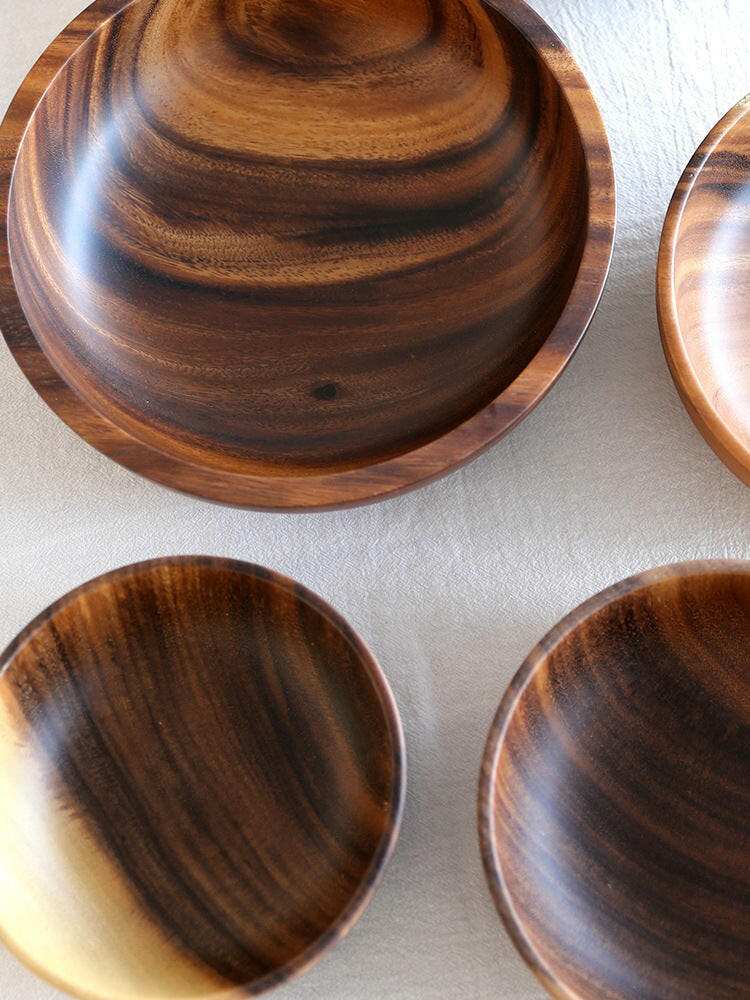 Acacia wood bowls with rich, varied hues and distinctive grain patterns.