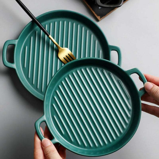 Green ceramic bakeware plates with handles, ideal for baking and serving.