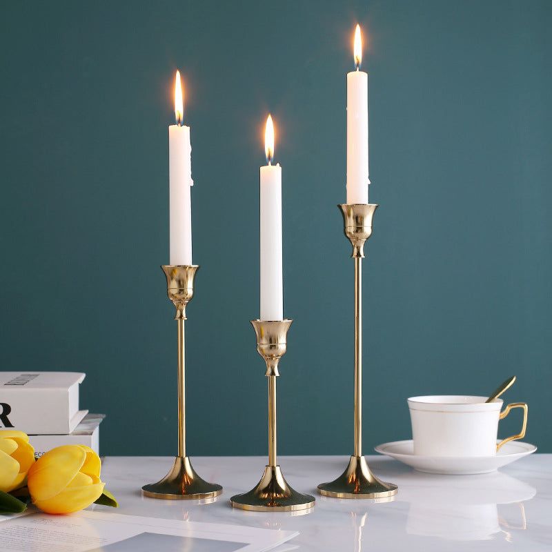 Vintage golden candle holder set with lit candles on a table, showcasing elegant design and opulent finish.