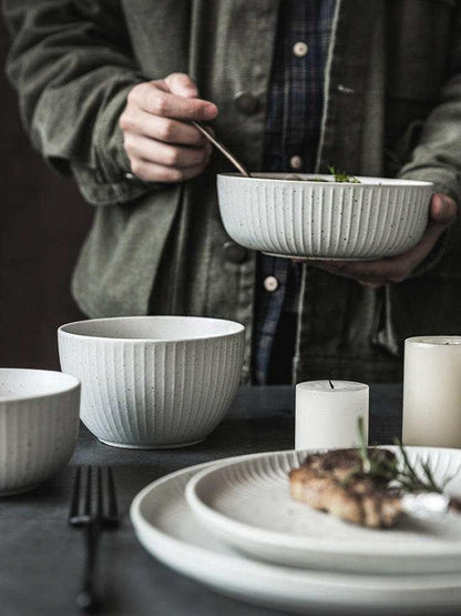 Stylized ceramic set with contemporary design, featuring bowls and plates.