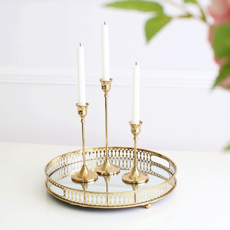 Vintage golden candle holder set on decorative tray.