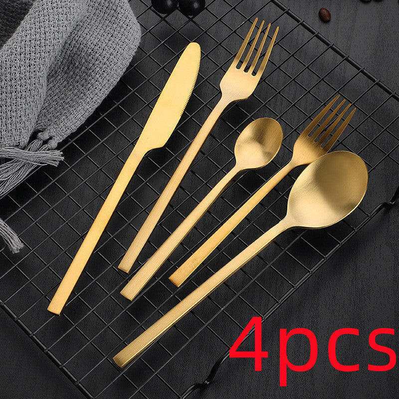 Matte stainless steel cutlery set with knife, fork, soup spoon, and teaspoon in gold finish.