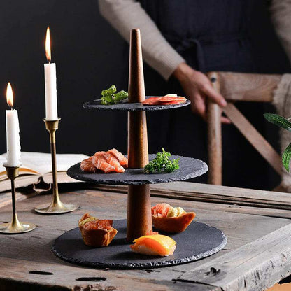 Multilayer board food tray with wood and black stone tiers for elegant presentation.