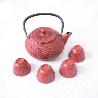 Red Teapot Set with cast iron teapot and four cups on white background.