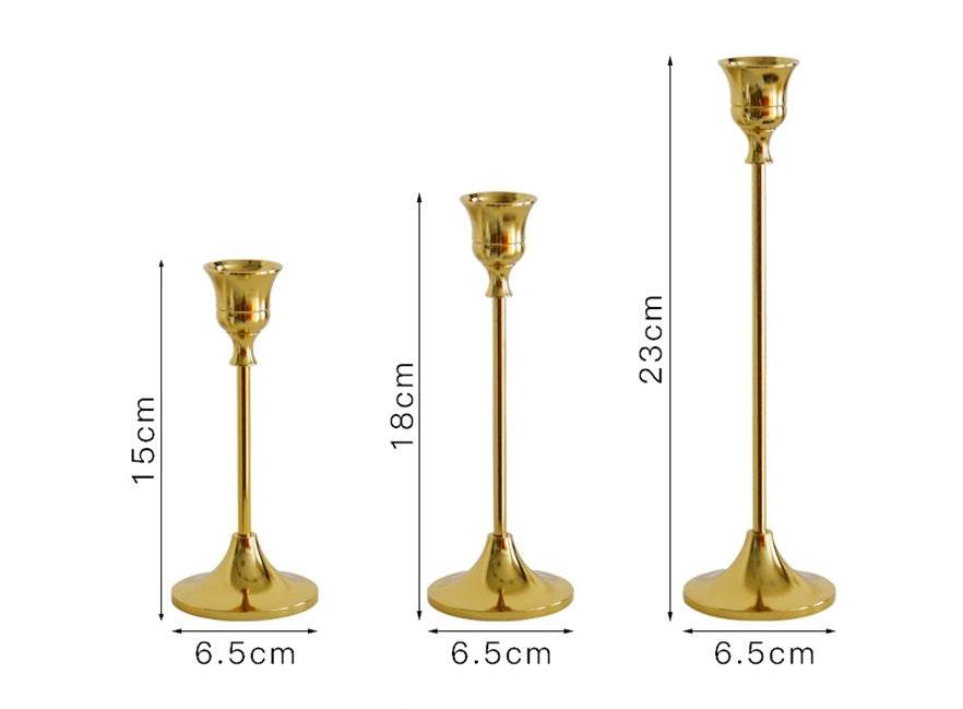 Vintage golden candle holder set with varying heights and elegant design.