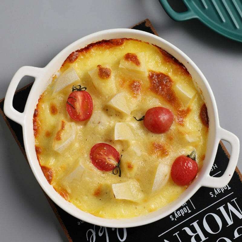 Round ceramic bakeware dish with handles.
