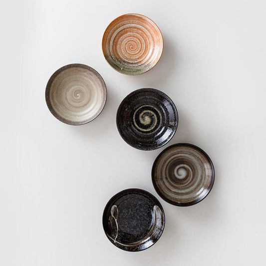 Retro Japanese ceramic plates with unique swirl patterns and textures, perfect for decor or dining.