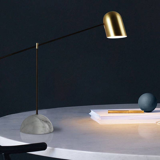 Modern marble table lamp with gold dome and sleek design on a white marble base.