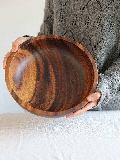 Handcrafted Acacia wood bowl featuring unique grain patterns.