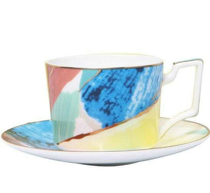 Colorful porcelain with vibrant hand-painted abstract design in blues, greens, oranges, and yellows on ceramic cup and saucer.