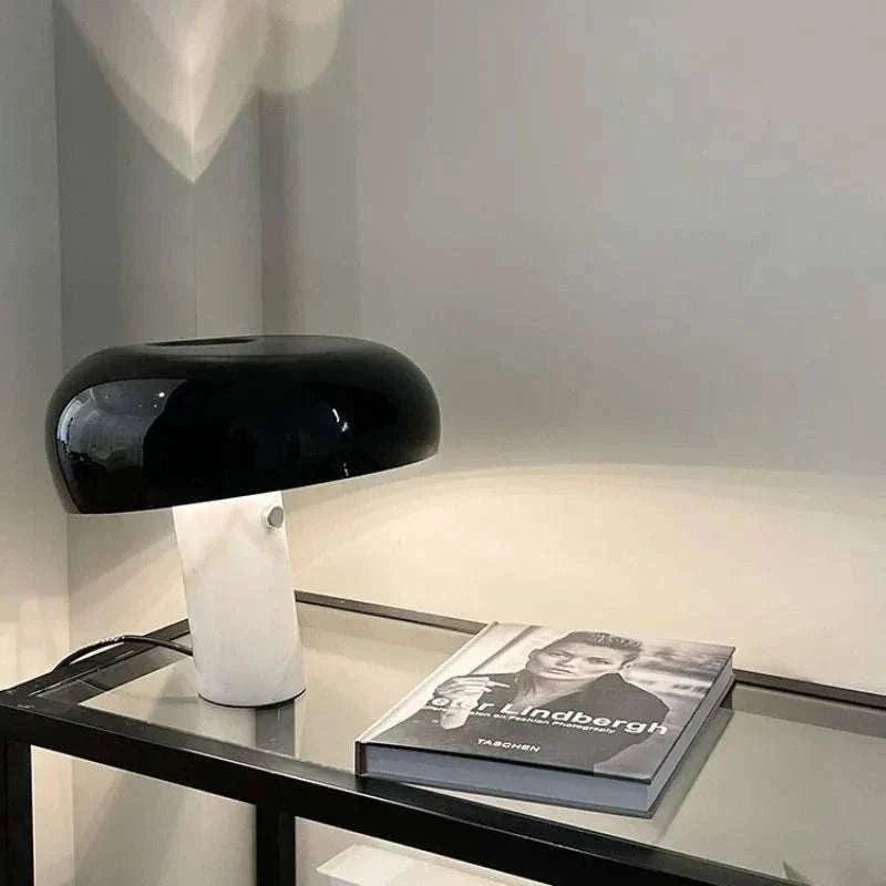 Snoopy Lamp with black mushroom shade and white base on glass table.