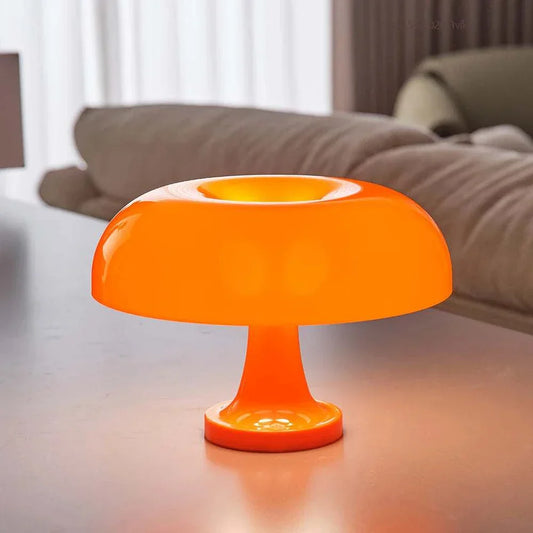 Orange mushroom table lamp on a surface, showcasing modern dome-like design.