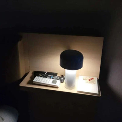 Rechargeable portable table lamp illuminating a desk with minimalist elegance.