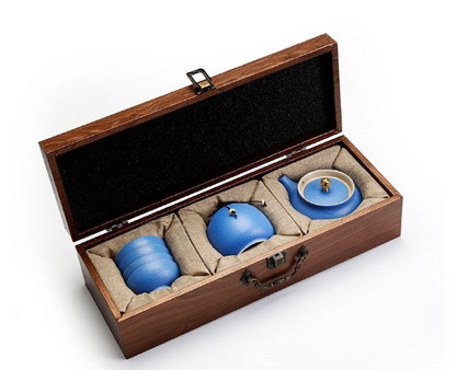 Traditional Japanese tea set with blue teapot and cups in decorative wooden box.