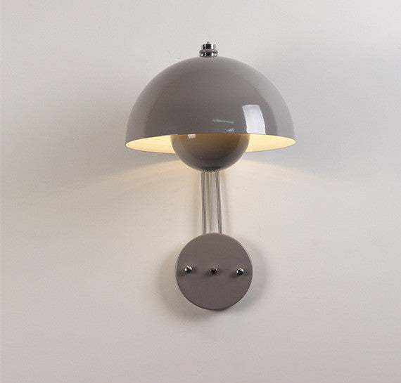 Flowerpot Lamp wall with a glossy dome-shaped shade providing a warm, intimate glow.